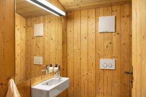 a bathroom with a white sink and wooden walls at Berghaus Wiesegg - Uriges Tiroler in Fügenberg +37 photos