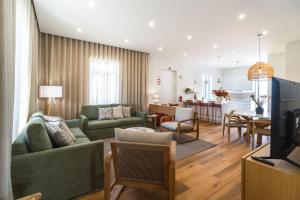 a living room with a couch and a dining room at Solar do Ilheuzinho in Câmara de Lobos