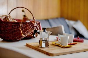 a coffee pot and two cups on a table with a basket at da Lule in Aosta