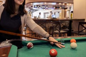 a woman playing billiard in a pool table at Hotel Grand Pas by Nexta in Pas de la Casa
