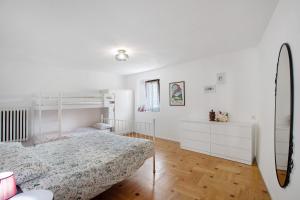 a bedroom with a bed and white walls and wooden floors at da Lule in Aosta