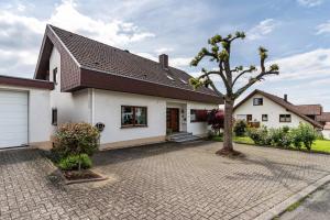 a white house with a tree in the driveway at Marlene in Friesenheim