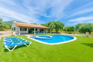 a pool with lounge chairs and a house at Sa Sargantana in Islas Baleares