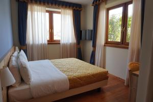 a bedroom with a bed and two windows at Giorgio e Flora Ristorante e Locanda in Arsiero