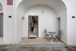 two chairs and a table in a white wall at Silvana's House in Agerola