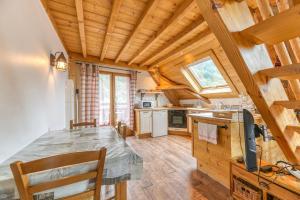 a kitchen with a table in a room with wooden ceilings at Auberge Passoud 203 in Vaujany