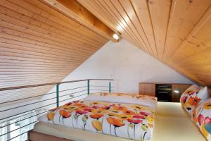 a bed in a room with a wooden ceiling at Ferienwohnung Lang, 45qm in Sasbach am Kaiserstuhl