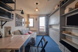 a small living room with a table and a couch at Studio Gaelle in Les Adrets