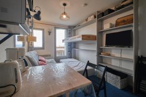 a room with a dining table and a living room at Studio Gaelle in Les Adrets