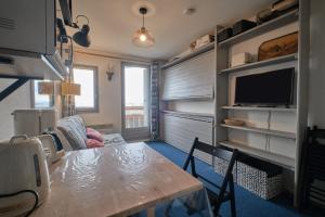 a small living room with a table and a tv at Studio Gaelle in Les Adrets +13 photos
