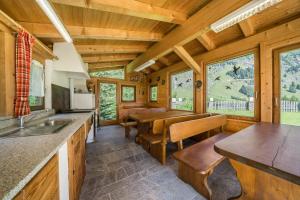 a kitchen and dining room with a table and benches at Ferienhaus Maria Steinröserl in Moso