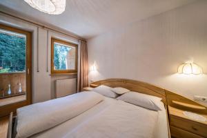 a bedroom with a bed with white sheets and a window at Ferienhaus Maria Steinröserl in Moso