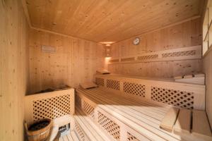 a wooden sauna with benches and a clock at Ferienhaus Maria Steinröserl in Moso +13 photos