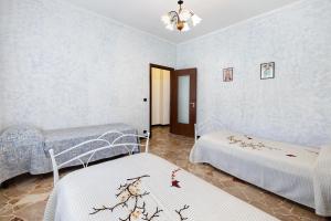 a bedroom with two beds and a chandelier at Casa Grace - Casa al Mare in Vado Ligure