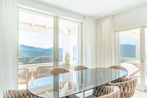 a dining room with a glass table and chairs at Elite Collection Villa Noemi in Porto Rotondo