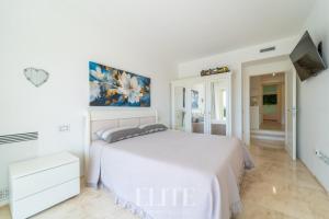 a white bedroom with a bed and a tv at Elite Collection Villa Noemi in Porto Rotondo +48 photos