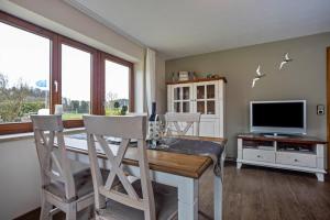 a dining room with a table and chairs and a television at Apfelhof Maurer in Lindau