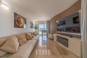 a living room with a large couch and a television at Elite Collection Villa Noemi in Porto Rotondo