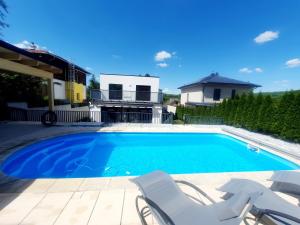 a swimming pool with two chairs and a house at Luxury Villa Vienna in Mauerbach
