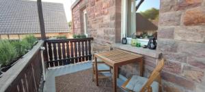 a patio with a wooden table and chairs on a balcony at Ferienwohnung Die Raspel in Melsungen +5 photos