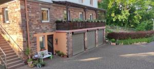a brick house with a gate and a balcony at Ferienwohnung Die Raspel in Melsungen