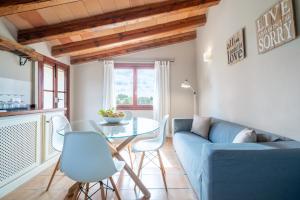 a living room with a blue couch and a glass table at Agroturismo Son Bauzanet in Palma de Mallorca
