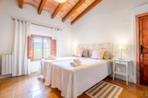 a white bedroom with two beds and a window at Agroturismo Son Bauzanet in Palma de Mallorca +43 photos
