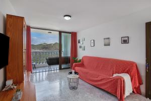 a living room with a red couch and a balcony at Hacienda Los Adejo in Moya