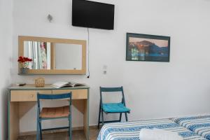 a bedroom with a desk and a bed and a mirror at Ilias Studios Sevasti Kalymnos in Panormos Kalymnos