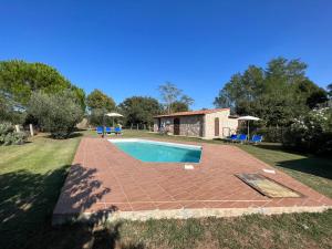 a swimming pool in a yard with a house at Roccia in Pitigliano