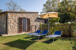 a couple of chairs and an umbrella in a yard at Roccia in Pitigliano