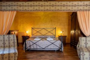 a bedroom with a bed and two chairs at Roccia in Pitigliano