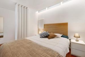 a bedroom with a large bed with a wooden headboard at Estoril Art and Surf in Estoril