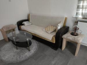 a living room with a couch and a glass table at Ferienwohnung In Krumbach in Krumbach