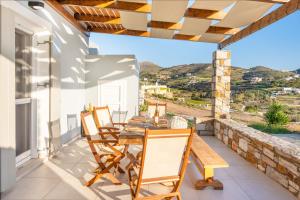a dining room with a table and chairs on a patio at Mont' Rock villas 3 in Posidhonía
