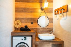 a bathroom with a sink and a washing machine at Mont' Rock villas 3 in Posidhonía