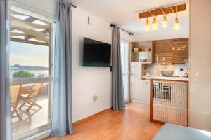 a kitchen and living room with a large window at Mont' Rock villas 3 in Posidhonía
