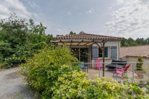 a house with a porch with pink chairs and a fence at Le Pequelet in Payzac