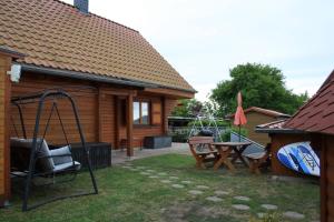 a yard with a swing and a table and a house at Ferienhaus Zuehlke in Groß Nemerow