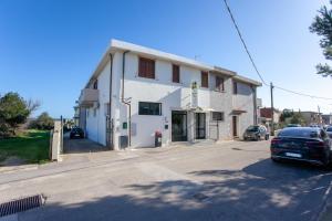 a white building with a car parked in front of it at Appartamento Melissa a Orosei in Orosei