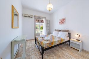 a bedroom with a bed and a desk and a window at Kassiopi Apartment 2 in Kassiopi +20 photos