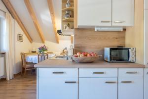 a kitchen with white cabinets and a bowl of fruit on a counter at Lotschenhof Apt Tulpe in Trodena