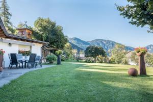 a garden with a table and chairs on a lawn at Lotschenhof Apt Tulpe in Trodena