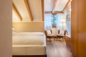 a bedroom with two beds and a desk and chairs at Lotschenhof Apt Tulpe in Trodena