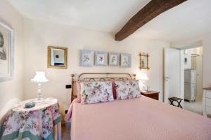 ein Schlafzimmer mit einem rosa Bett und einem Tisch in der Unterkunft Casa dei Tigli in Ormea
