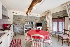 eine Küche mit einem roten Tisch und Stühlen in einem Zimmer in der Unterkunft Casa dei Tigli in Ormea