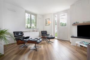 a living room with three chairs and a flat screen tv at Villa Angelina in Lavagna