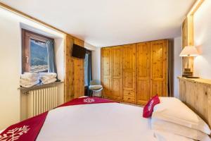a bedroom with a bed and wooden cabinets and a window at Il Nido di Letizia in Châtillon