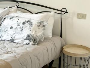a bed with a black and white pillow and a table at a due passi da Conegliano in Capo di Sotto +30 photos