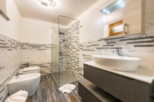 a white bathroom with a sink and a toilet at Il Nido di Letizia in Châtillon +15 photos